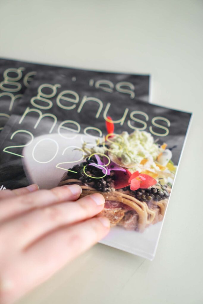 Detailansicht mit Hand vom Genussmesse 2023 Programmheft © Sophie Wurnig